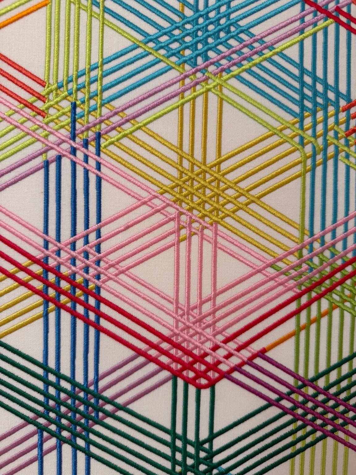 The Shape of Connection (detail) — close-up of intersecting coloured threads that create layered cubes and overlapping edges