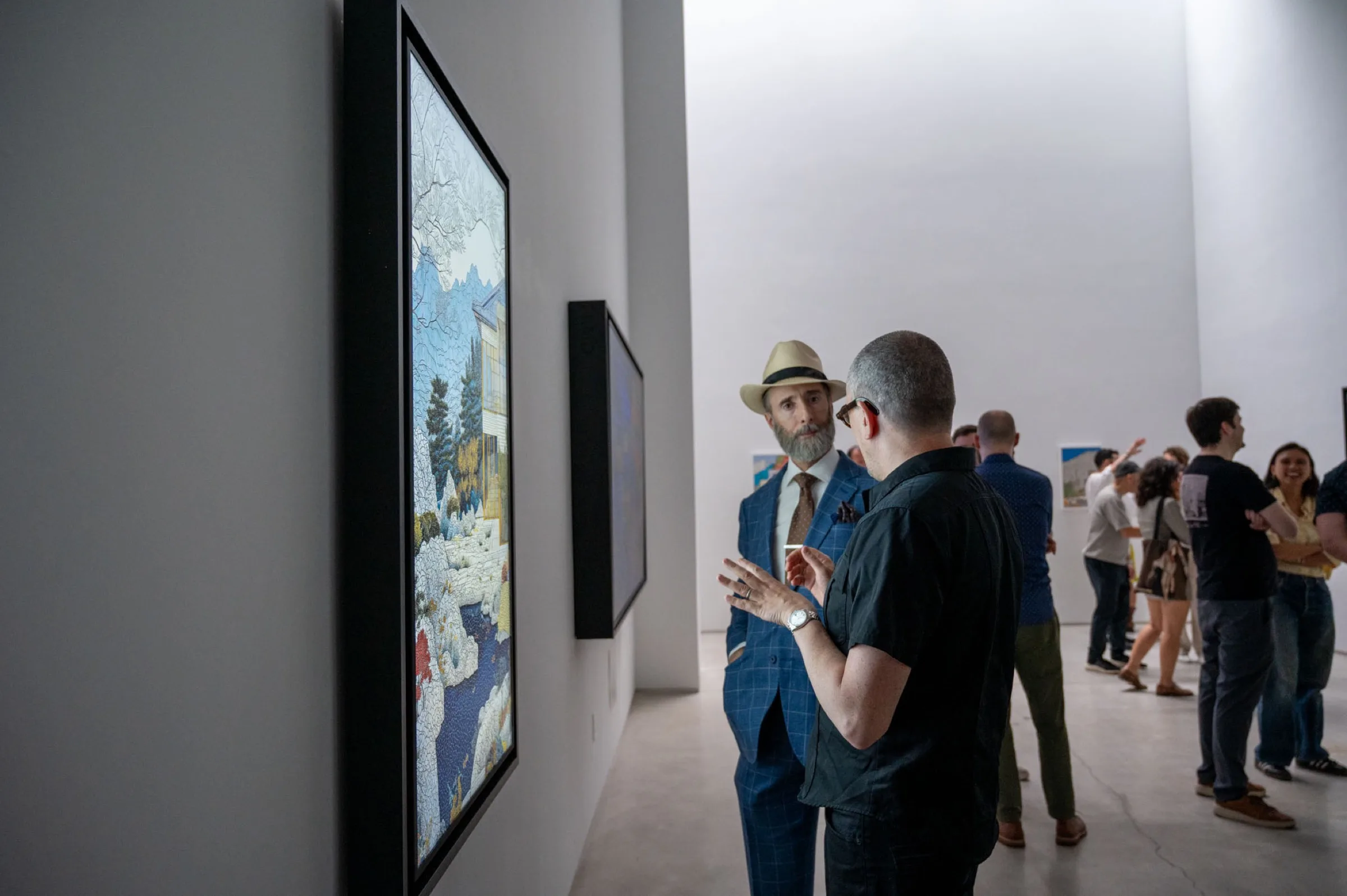 Event view with people engaging in conversation around the artworks.
