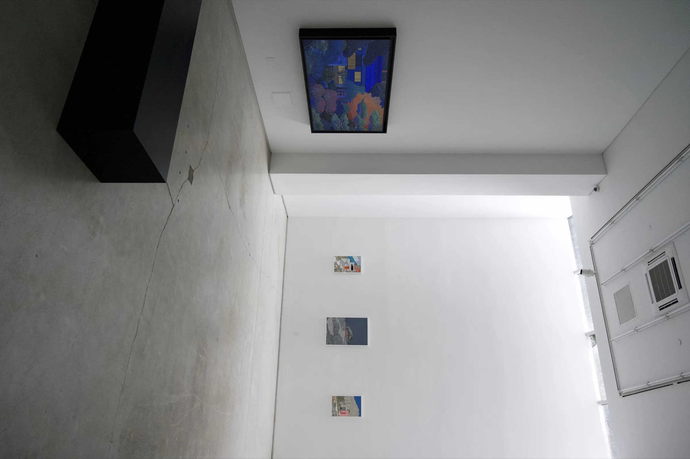 Wide installation gallery view with multiple works on white walls.
